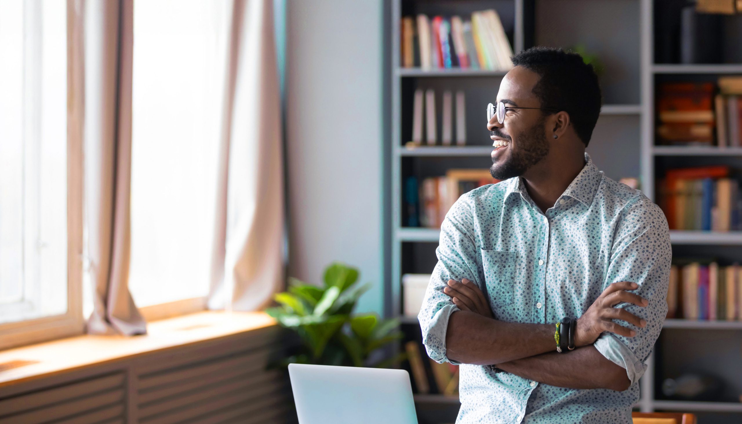 man smiling looking out window in an office