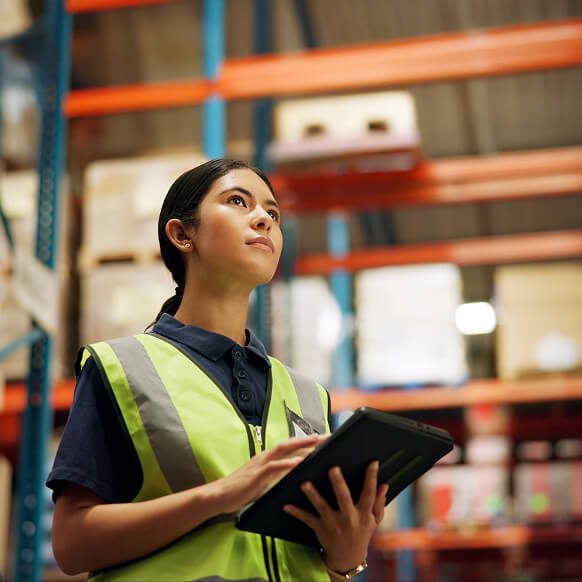 A woman working with a data pad in a warehouse