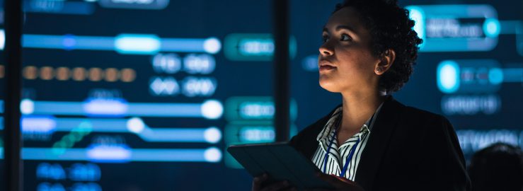 A woman working on a computer in a dark office environment